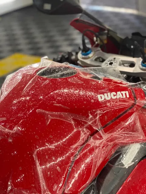 Tanque vermelho de uma Ducati com a película sendo esticada